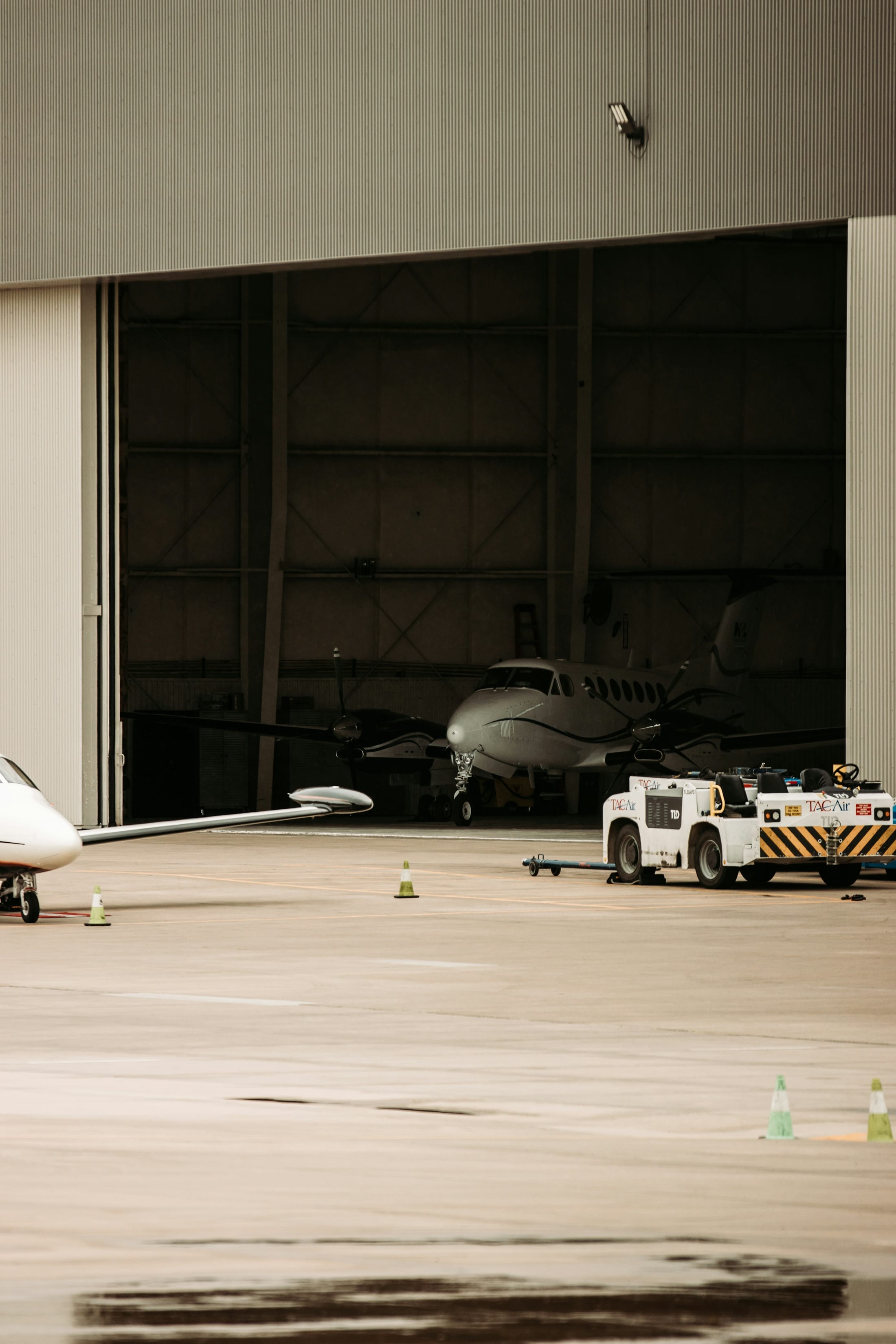 Jet ejecutivo y tractor de remolque frente a un hangar